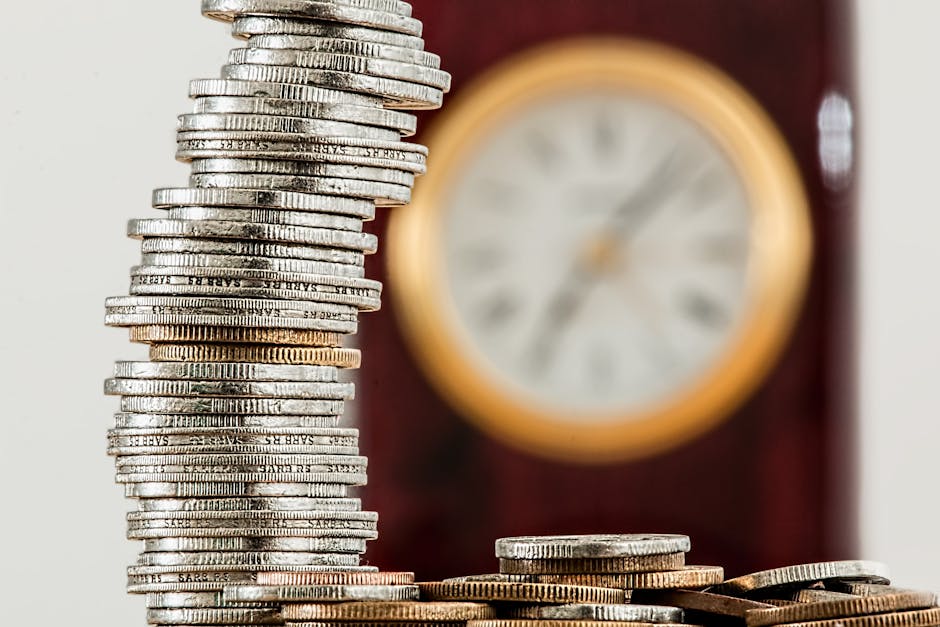 A close-up image of stacked coins with a blurred clock, symbolizing time and money relationship