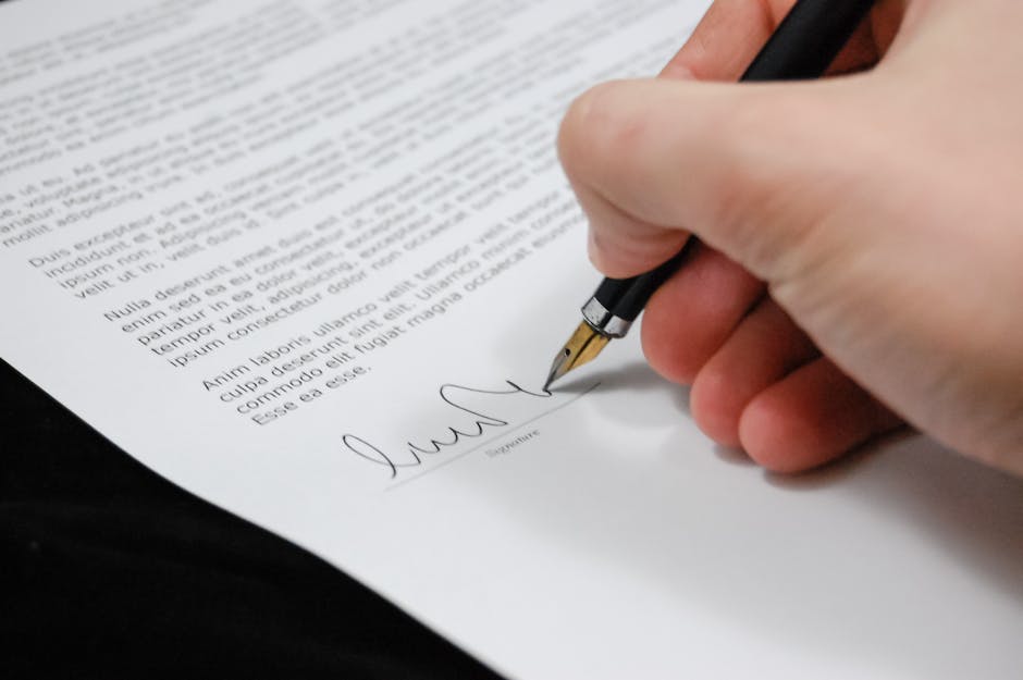 Close-up of a hand signing a legal document with a fountain pen, symbolizing signature and agreement